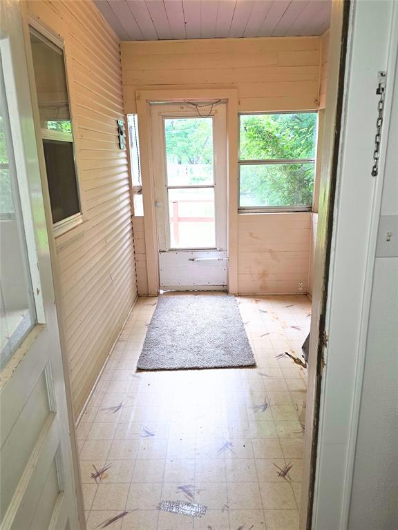 926 S 9th St, Chickasha, OK 73018 - entryway with wood walls, light flooring, and wood ceiling