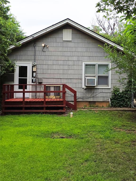 926 S 9th St, Chickasha, OK 73018 - back of property featuring a wooden deck and a yard