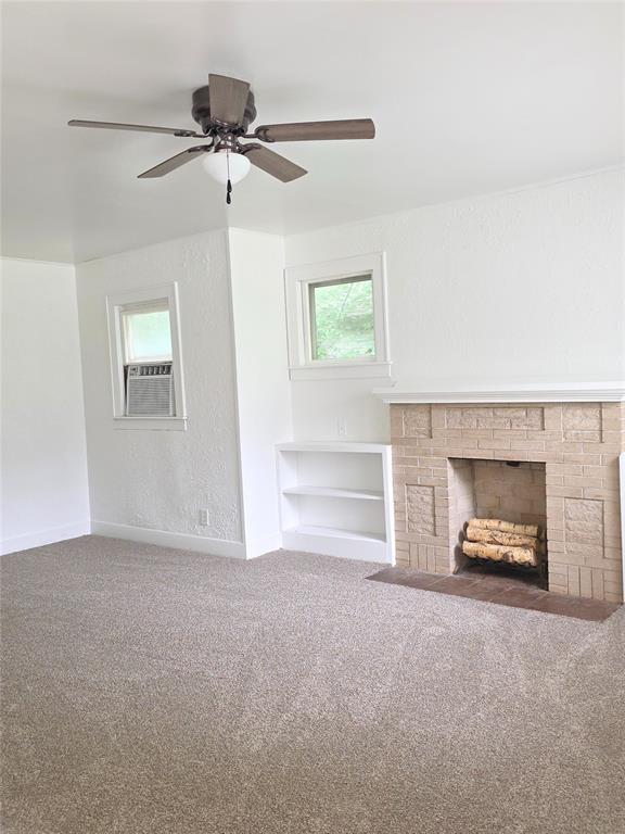 926 S 9th St, Chickasha, OK 73018 - unfurnished living room with carpet flooring, a ceiling fan, a fireplace, and cooling unit