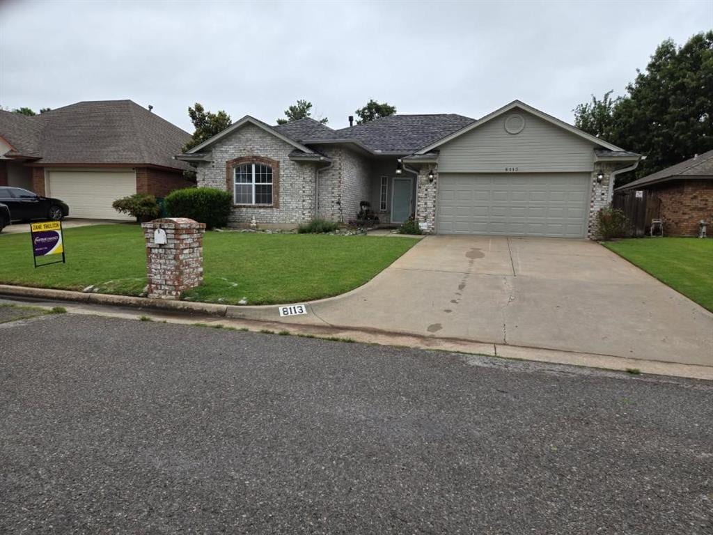 8113 Turtle Dove Dr, Oklahoma City, OK 73132 - view of front facade featuring a garage, a front lawn, driveway, and brick siding