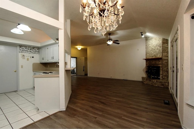 8113 Turtle Dove Dr, Oklahoma City, OK 73132 - kitchen featuring open floor plan, light wood-type flooring, a ceiling fan, vaulted ceiling, and a brick fireplace