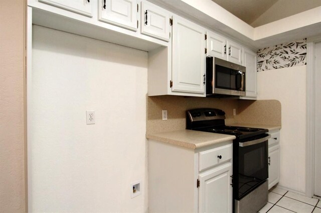 8113 Turtle Dove Dr, Oklahoma City, OK 73132 - kitchen featuring stainless steel microwave, electric stove, light countertops, white cabinets, and light tile patterned flooring