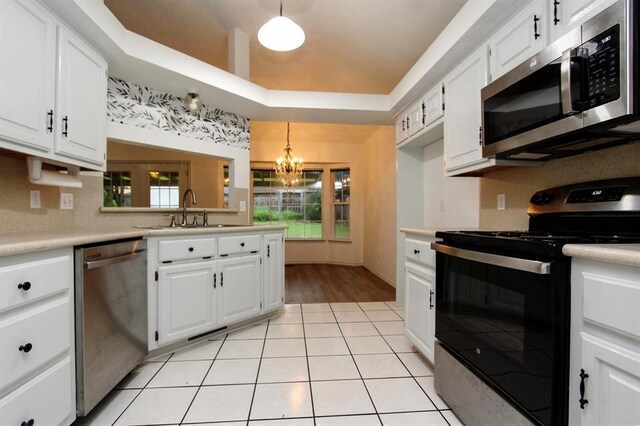 8113 Turtle Dove Dr, Oklahoma City, OK 73132 - kitchen with appliances with stainless steel finishes, light countertops, a chandelier, and white cabinets
