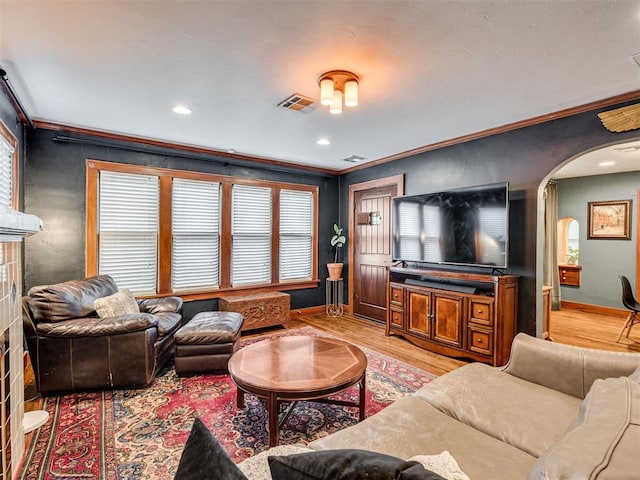 1616 NW 41st St, Oklahoma City, OK 73118 - living room with baseboards, arched walkways, light wood finished floors, healthy amount of natural light, and ornamental molding