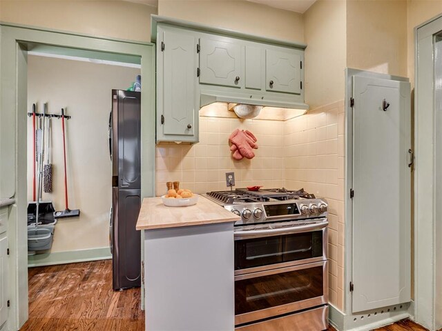 1616 NW 41st St, Oklahoma City, OK 73118 - kitchen featuring range with two ovens, under cabinet range hood, butcher block counters, and wood finished floors