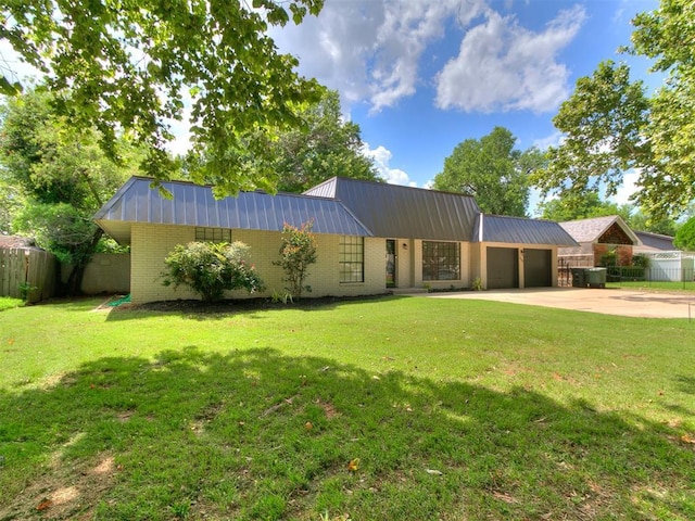 1117 Washington St, Edmond, OK 73034 - view of front of property with an attached garage, a metal roof, concrete driveway, and brick siding