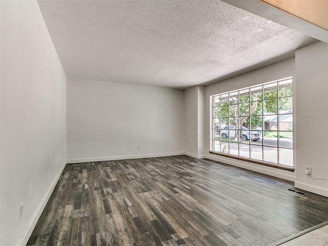 1117 Washington St, Edmond, OK 73034 - spare room featuring dark wood-style floors and a textured ceiling