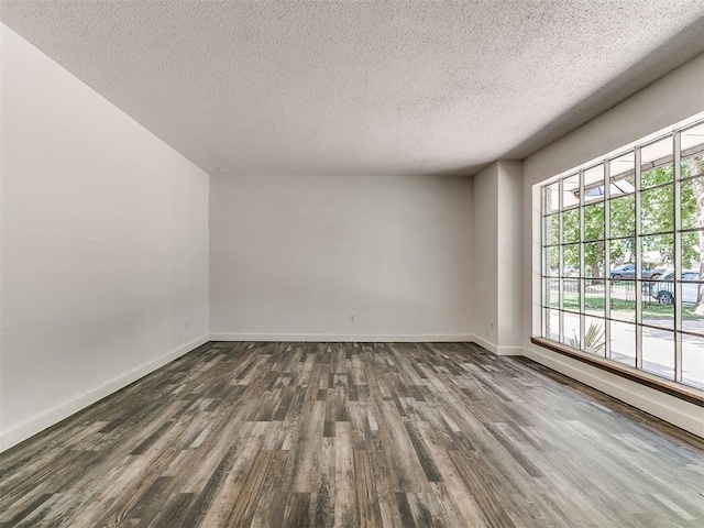 1117 Washington St, Edmond, OK 73034 - empty room with dark wood finished floors and a textured ceiling
