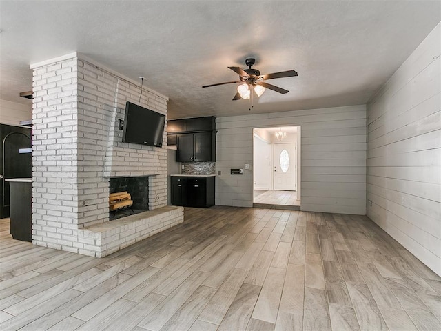 1117 Washington St, Edmond, OK 73034 - unfurnished living room with ceiling fan, light wood-style flooring, and a fireplace
