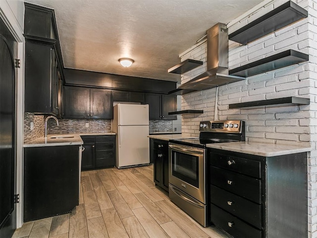1117 Washington St, Edmond, OK 73034 - kitchen featuring freestanding refrigerator, electric range, dark cabinetry, backsplash, and light countertops