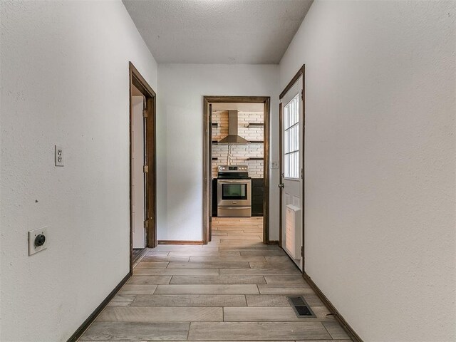 1117 Washington St, Edmond, OK 73034 - corridor with light wood-type flooring and a textured ceiling