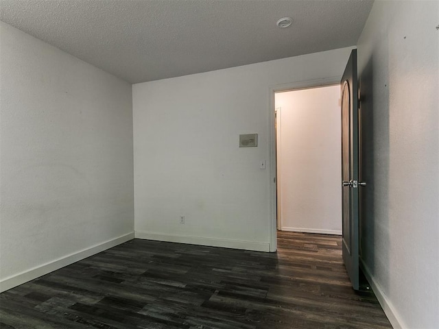 1117 Washington St, Edmond, OK 73034 - empty room with dark wood finished floors and a textured ceiling