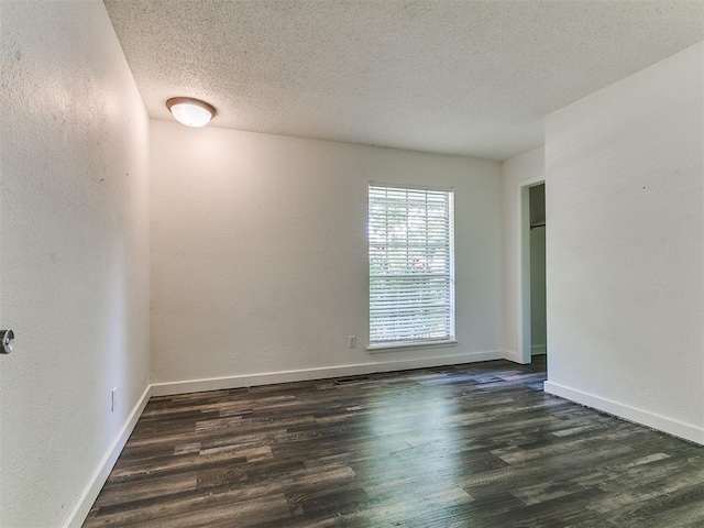 1117 Washington St, Edmond, OK 73034 - empty room with wood finished floors, a textured ceiling, and a textured wall