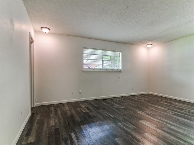 1117 Washington St, Edmond, OK 73034 - unfurnished room featuring a textured ceiling and dark wood-style flooring