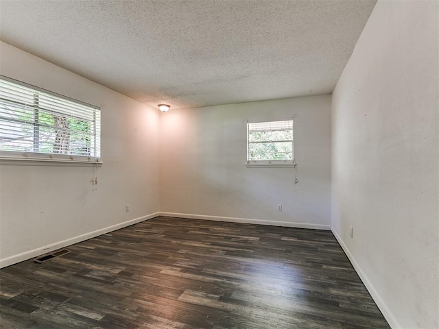1117 Washington St, Edmond, OK 73034 - empty room with a textured ceiling, healthy amount of natural light, and wood finished floors