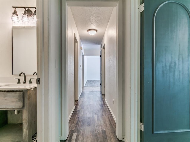 1117 Washington St, Edmond, OK 73034 - corridor featuring a textured ceiling and dark wood-style flooring