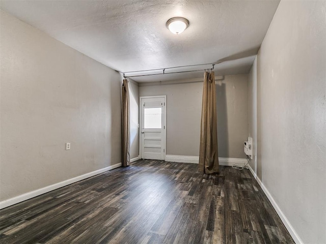 1117 Washington St, Edmond, OK 73034 - spare room featuring dark wood finished floors and a textured ceiling