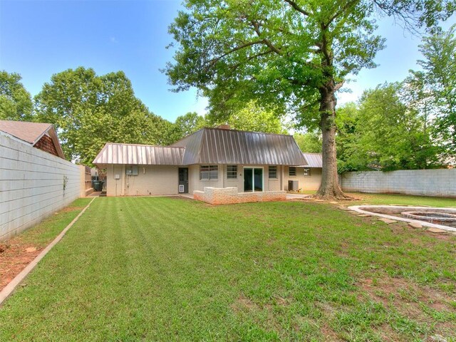 1117 Washington St, Edmond, OK 73034 - back of house featuring a metal roof and a fenced backyard