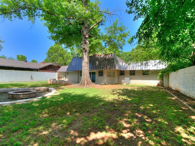 1117 Washington St, Edmond, OK 73034 - fenced backyard featuring an outdoor fire pit