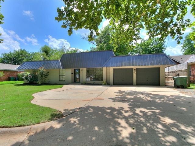 1117 Washington St, Edmond, OK 73034 - view of front of property with brick siding, a metal roof, an attached garage, and driveway