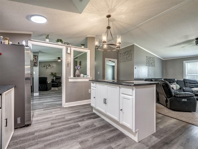 3 Antler Blvd, Mcloud, OK 74851 - kitchen with freestanding refrigerator, a textured ceiling, a ceiling fan, white cabinetry, and wood finished floors