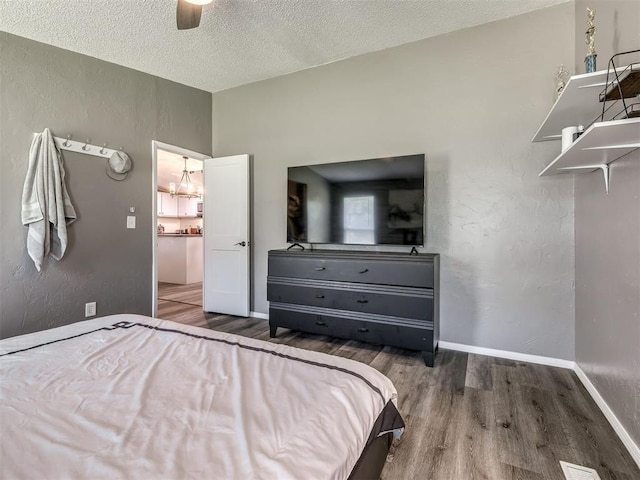 3 Antler Blvd, Mcloud, OK 74851 - bedroom with wood finished floors, a textured ceiling, baseboards, a chandelier, and a ceiling fan