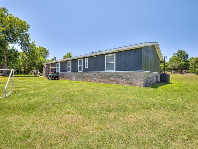 3 Antler Blvd, Mcloud, OK 74851 - rear view of property featuring central air condition unit, a yard, and brick siding