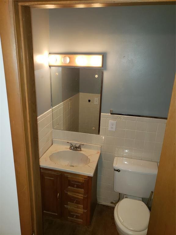 214 N Pecan St, Crescent, OK 73028 - half bathroom featuring vanity, tile walls, and a wainscoted wall
