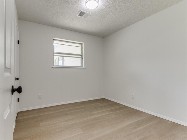 7017 S Miller Ave, Oklahoma City, OK 73159 - unfurnished room with light wood-style floors and a textured ceiling