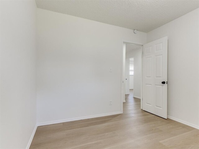 7017 S Miller Ave, Oklahoma City, OK 73159 - unfurnished room featuring light wood-style flooring and a textured ceiling