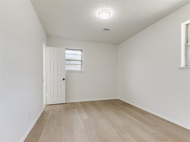 7017 S Miller Ave, Oklahoma City, OK 73159 - unfurnished room with a textured ceiling and light wood-type flooring