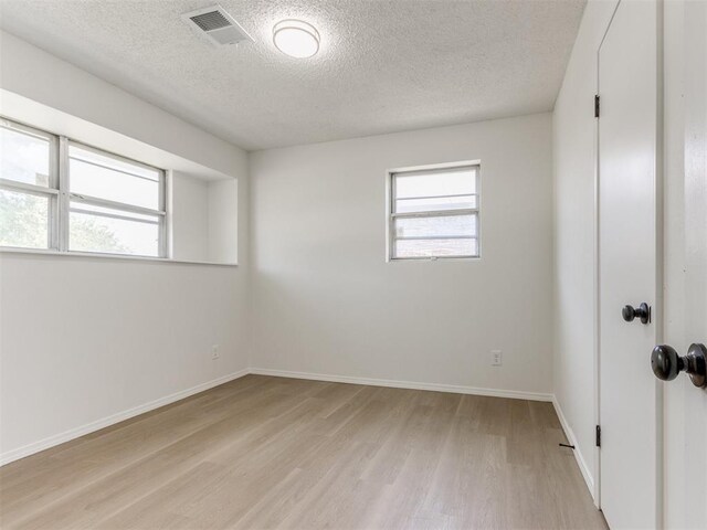 7017 S Miller Ave, Oklahoma City, OK 73159 - unfurnished room featuring light wood finished floors and a textured ceiling