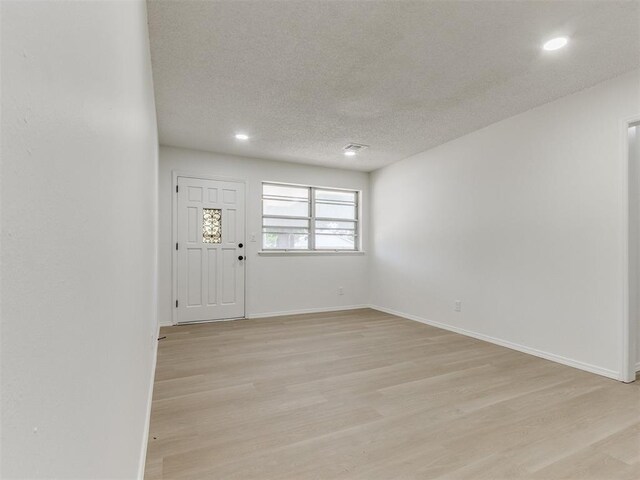 7017 S Miller Ave, Oklahoma City, OK 73159 - foyer entrance featuring light wood finished floors, a textured ceiling, and recessed lighting