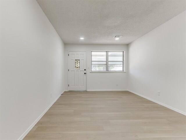 7017 S Miller Ave, Oklahoma City, OK 73159 - foyer entrance with a textured ceiling, light wood-style flooring, and recessed lighting