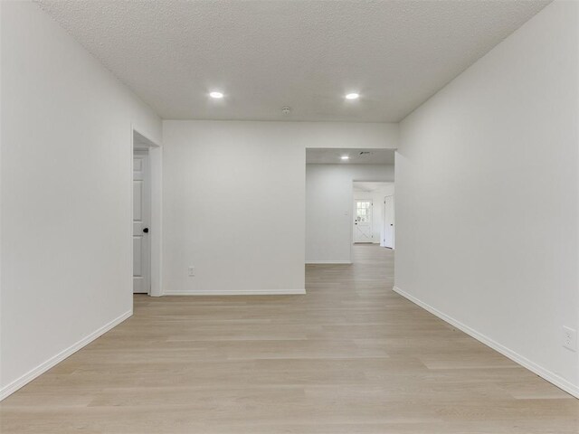 7017 S Miller Ave, Oklahoma City, OK 73159 - empty room featuring light wood finished floors, a textured ceiling, and recessed lighting