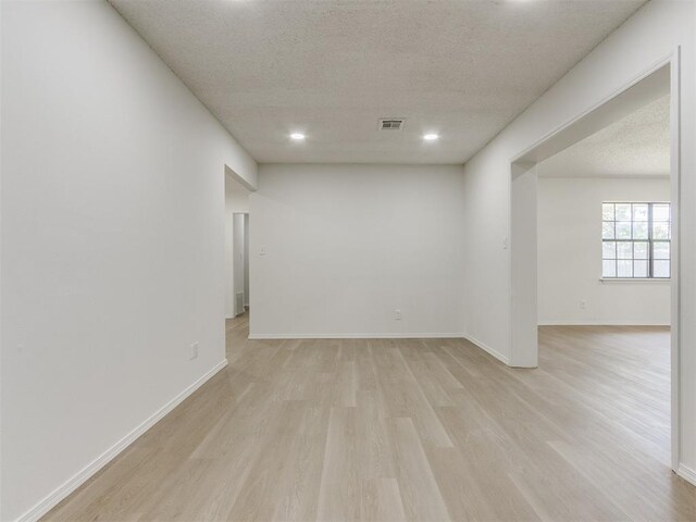 7017 S Miller Ave, Oklahoma City, OK 73159 - spare room featuring light wood-style floors and a textured ceiling