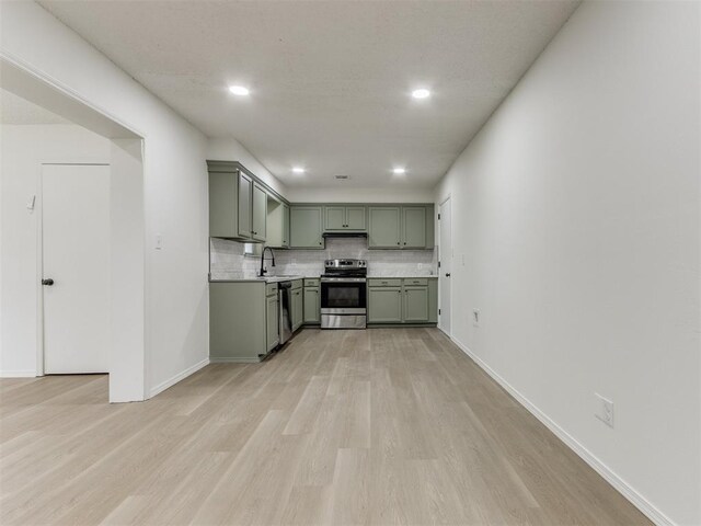 7017 S Miller Ave, Oklahoma City, OK 73159 - kitchen featuring green cabinets, stainless steel appliances, light wood-style floors, decorative backsplash, and light countertops