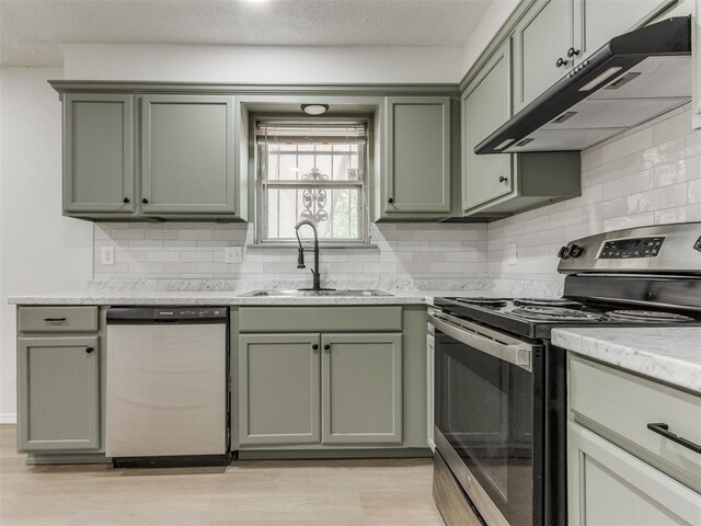 7017 S Miller Ave, Oklahoma City, OK 73159 - kitchen featuring appliances with stainless steel finishes, green cabinetry, under cabinet range hood, backsplash, and a textured ceiling