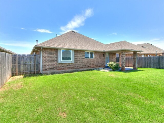 2517 NW 194th St, Edmond, OK 73012 - rear view of property featuring brick siding, a shingled roof, and a fenced backyard