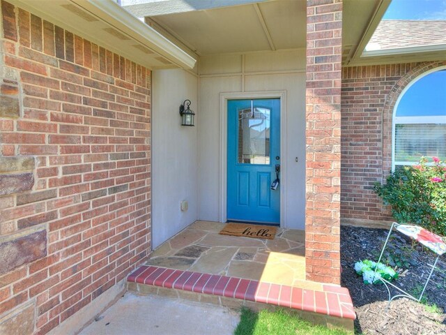 2517 NW 194th St, Edmond, OK 73012 - view of exterior entry with brick siding and a shingled roof