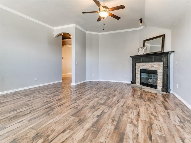 2517 NW 194th St, Edmond, OK 73012 - unfurnished living room with ceiling fan, wood finished floors, arched walkways, a stone fireplace, and vaulted ceiling