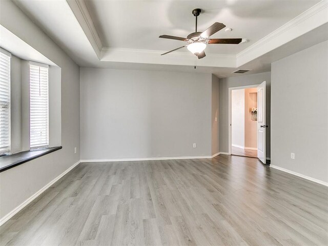 2517 NW 194th St, Edmond, OK 73012 - spare room with a tray ceiling, ornamental molding, a ceiling fan, and wood finished floors
