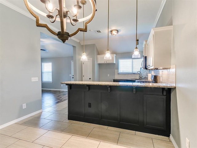 2517 NW 194th St, Edmond, OK 73012 - kitchen featuring white cabinetry, tasteful backsplash, light stone counters, a chandelier, and a breakfast bar