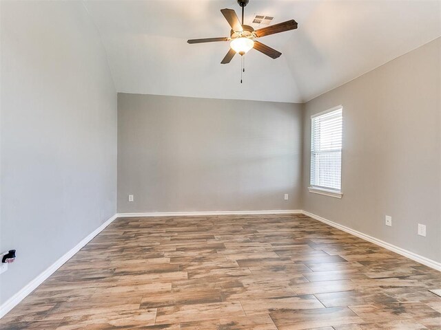 2517 NW 194th St, Edmond, OK 73012 - spare room with vaulted ceiling, a ceiling fan, and wood finished floors