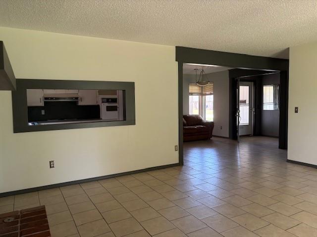 5720 Rushing Rd, Oklahoma City, OK 73132 - unfurnished room featuring a textured ceiling and light tile patterned flooring