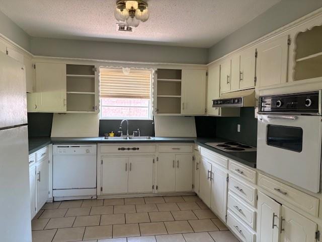 5720 Rushing Rd, Oklahoma City, OK 73132 - kitchen with white appliances, open shelves, under cabinet range hood, a textured ceiling, and dark countertops