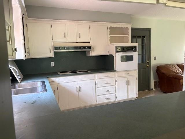 5720 Rushing Rd, Oklahoma City, OK 73132 - kitchen with under cabinet range hood, white appliances, open shelves, and white cabinets
