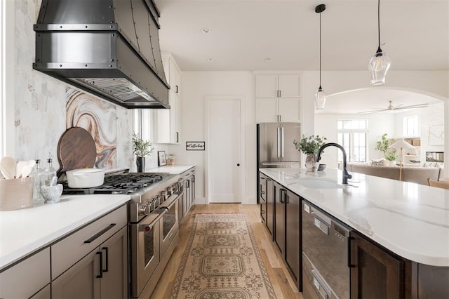 1700 Runway Blvd, Oklahoma City, OK 73108 - kitchen featuring island exhaust hood, stainless steel appliances, light wood-type flooring, and a kitchen island with sink