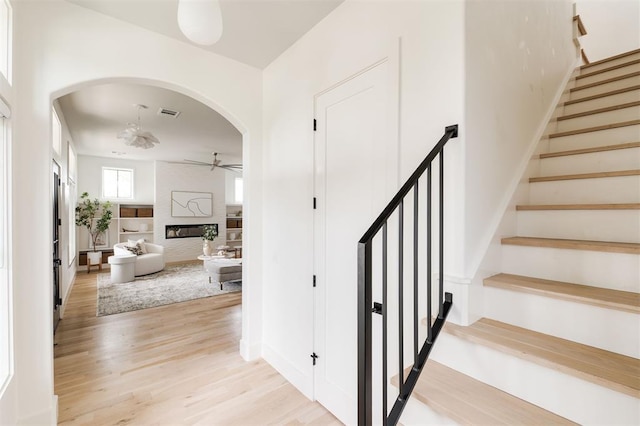 1700 Runway Blvd, Oklahoma City, OK 73108 - stairway with a ceiling fan, arched walkways, wood finished floors, and a fireplace