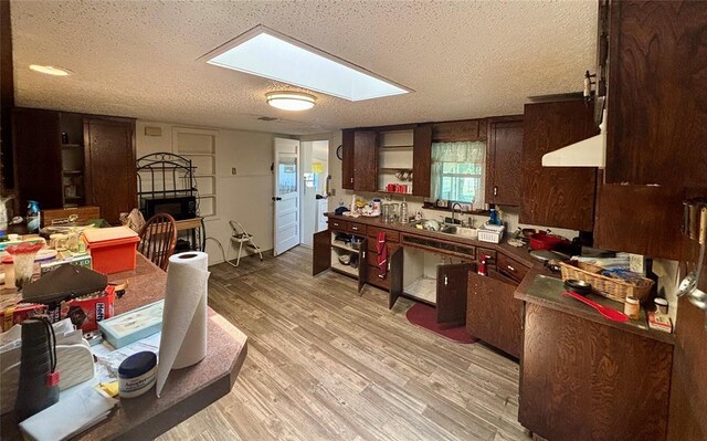 5311 S Cason Rd, Marlow, OK 73055 - kitchen with a textured ceiling, a fireplace, light wood finished floors, open shelves, and a sink